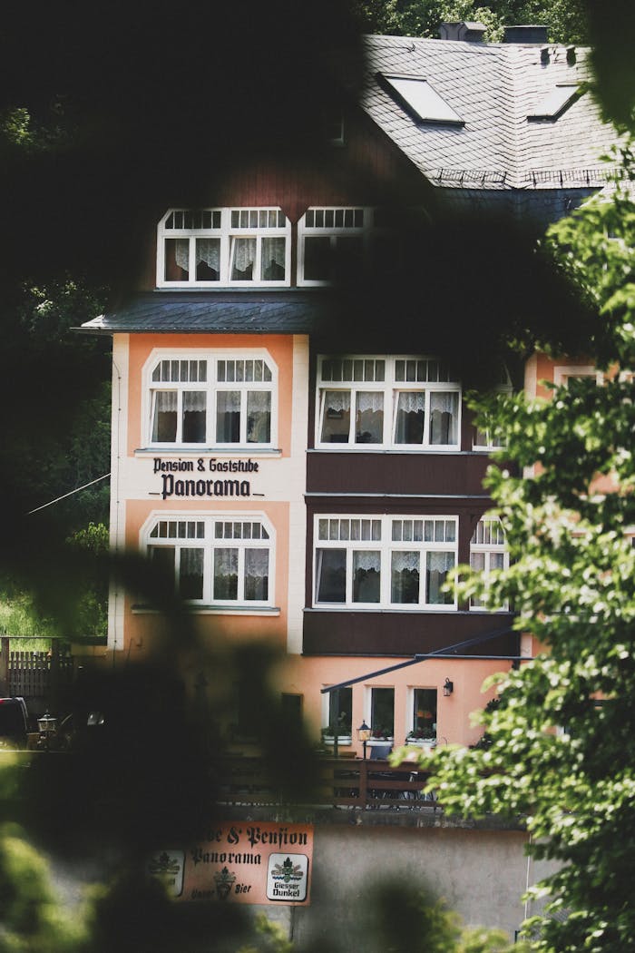 European guesthouse 'Panorama' framed by lush greenery, evoking a serene retreat.
